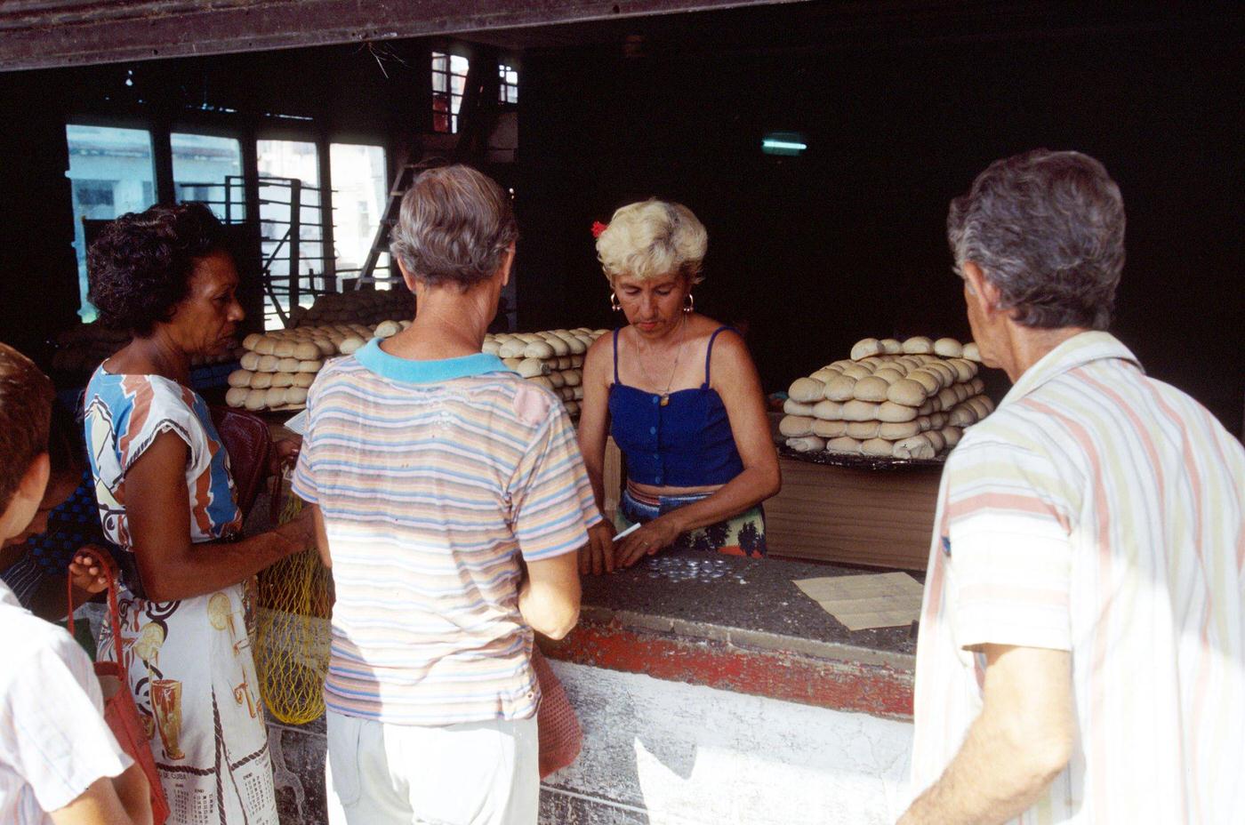 #35 Cuban woman serving people at a public shop using the ration book in Havana, Cuba, 1990.