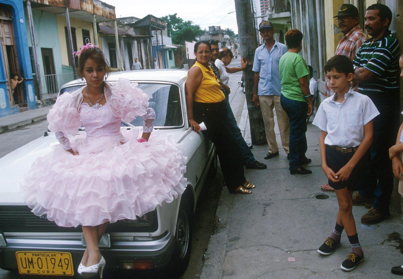 #1 Cuban little girl posing in an elegant dress for a 15th birthday celebration, Cuba, 1990.