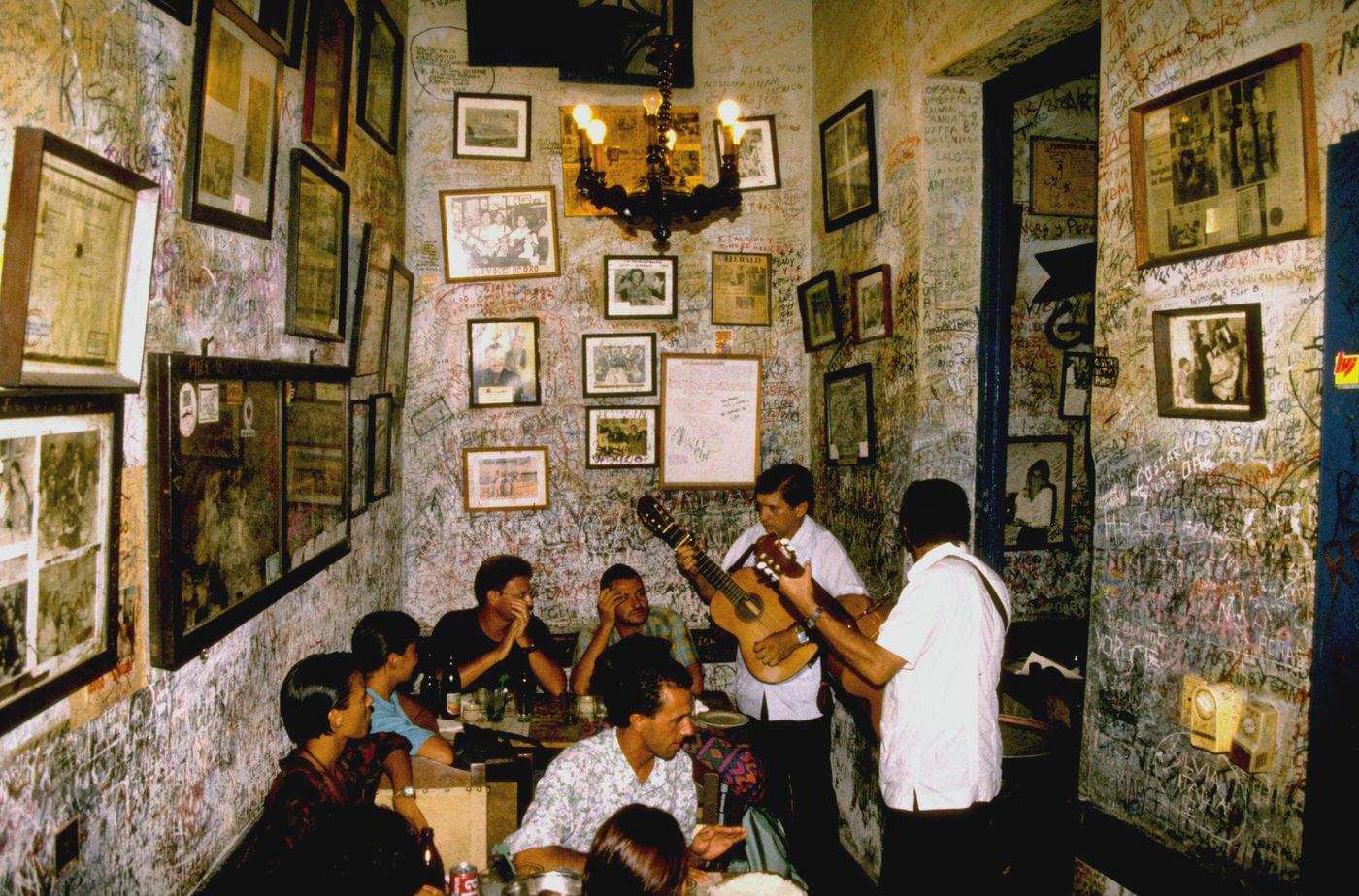 #43 Two Cuban musicians playing guitar at the bar restaurant La Bodeguita del Medio in Havana, Cuba, 1990.