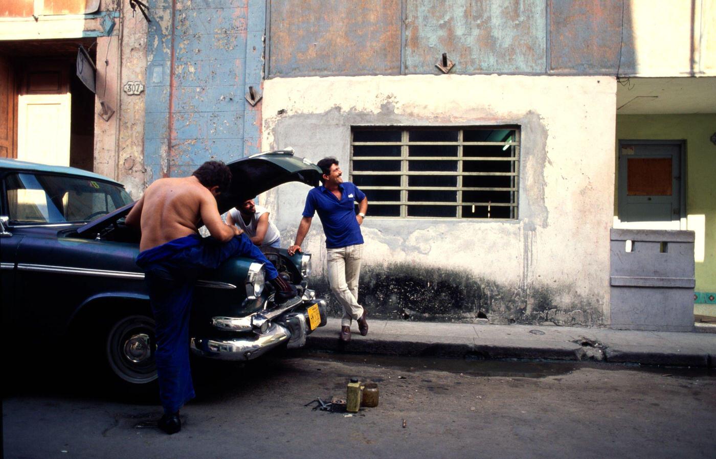 #59 Cuban men trying to fix a 1950’s American car in downtown Havana, Cuba, 1991.