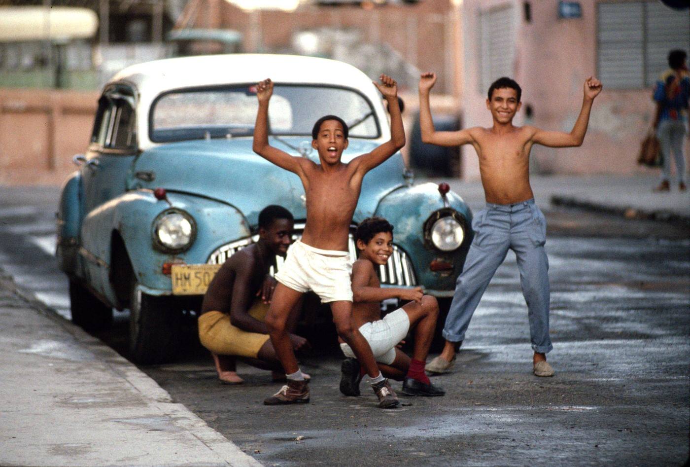#62 Young Cuban boys having fun as they clean a 1950’s American car in downtown Havana, Cuba, 1991.