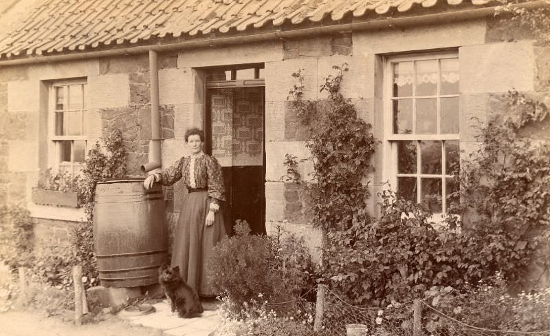 #16 Edwardian lady and dog standing outside a single storey house