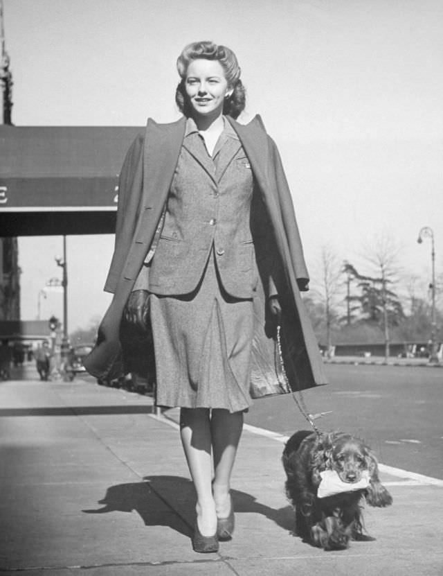#8 Model Mimi Berry walked her cocker spaniel, who carried a package for her, 1944.