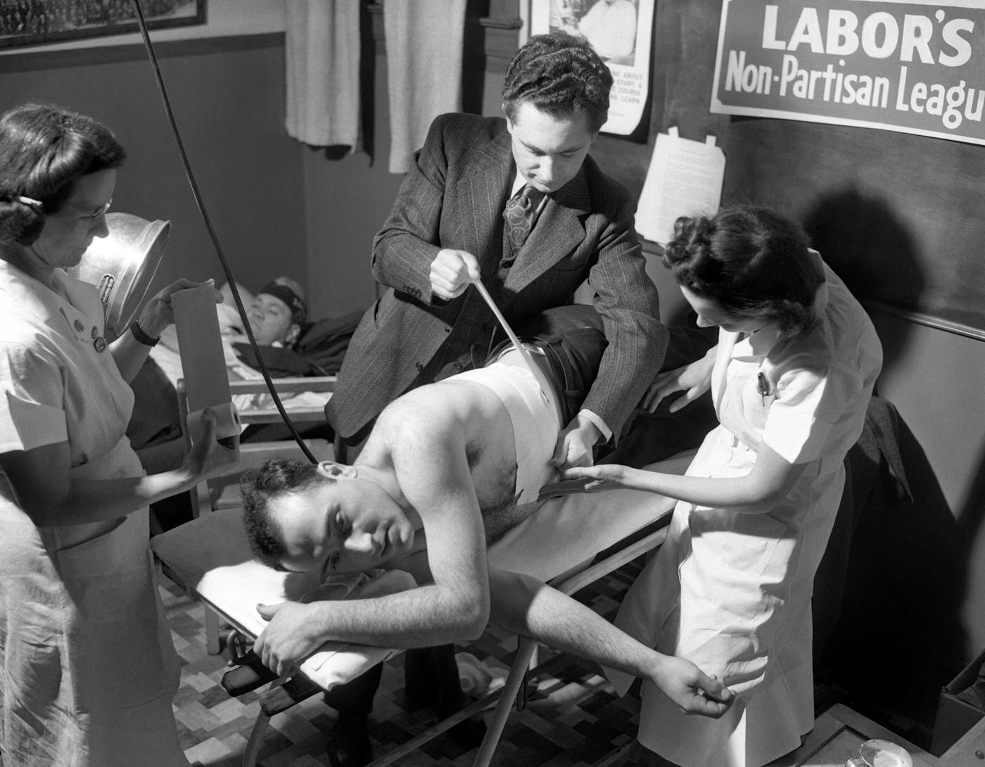 #11 A man has his side taped after being injured in the riots during the Ford Motor Company strike at the River Rouge Plant in Dearborn, Michigan, April 9, 1941