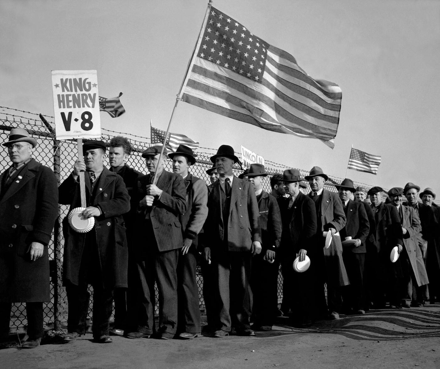 #13 Workers from the Ford Motor Company hold American Flags near the River Rouge plant during the Detroit Ford Labor strike in Dearborn, Michigan, April 11, 1941.