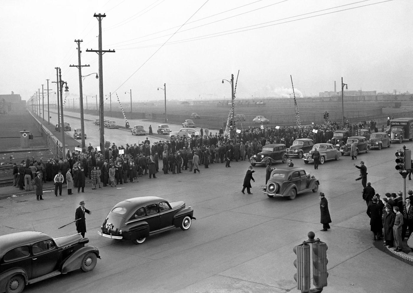 #9 A large crowd of people stand on the sidewalk during the Detroit Ford Motor Company Labor Strike near the Ford River Rouge complex in Dearborn, Michigan, April 1941