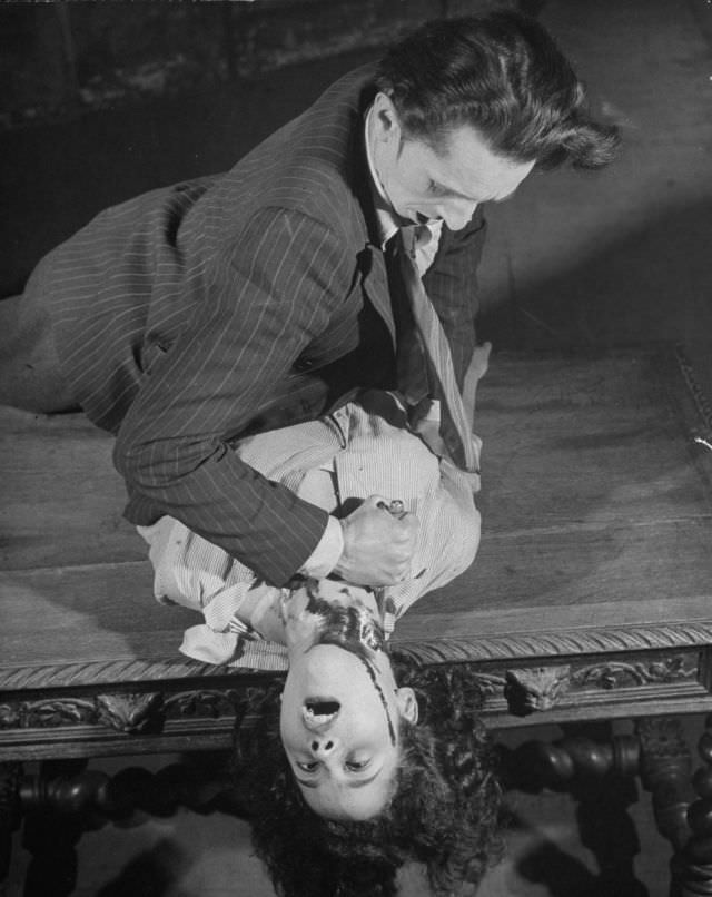 #7 Actor dramatizing the realistic stabbing trick in production at the Grand Guignol Theater.