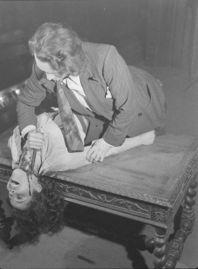 #9 Actor dramatizing the realistic stabbing trick in production at the Grand Guignol Theater.