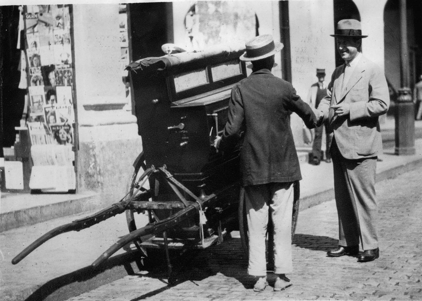 #7 Cognac producer Paul Martell with a street musician in Havana, 1930