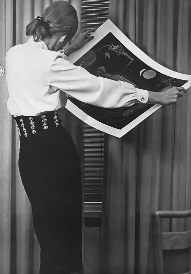 #13 Model in white jewel-buttoned blouse by Florence Gainor and wide decorated belt by Midtown, Vogue, 1945.
