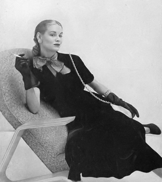 #25 Natalie Paine in soot-black velveteen dress fastens at the side with shirring at the right shoulder by Aywon, worn with big taffeta bow by Emily Wetherby, Harper’s Bazaar, 1947.