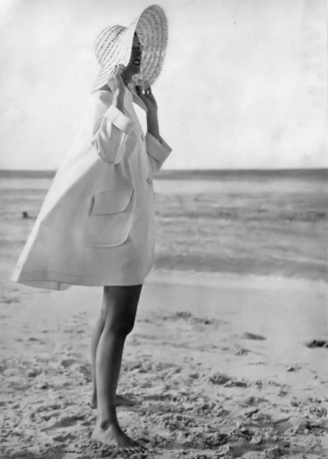 #40 Model in sea-going topcoat of stiff white poplin with big collar and patch pockets by Sunclothes, at British Colonial Beach, Bahamas, Harper’s Bazaar, 1948.
