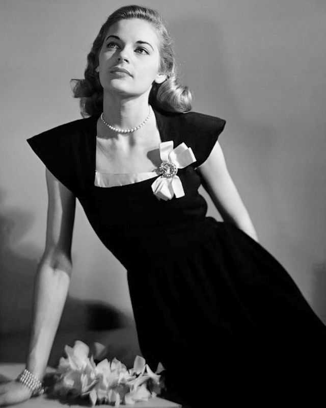 #7 Model in black dress with pink bordered neckline, bow in corner, Marvella bracelet, Glamour, 1945.