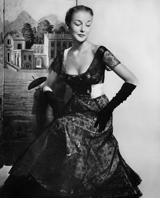 #2 Liz Pringle in pink silk taffeta with a delicate tracery of black lace embroidered with clusters of rhinestones, the waist is bound with a wide pink satin sash, Harper’s Bazaar, October 1948