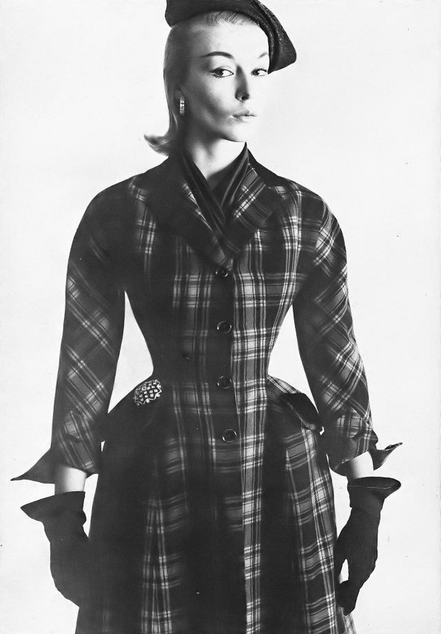 #20 Liz Pringle in fitted, plaid coat of red and black wool, side-swing black straw hat, all by Christian Dior-New York, February 1952
