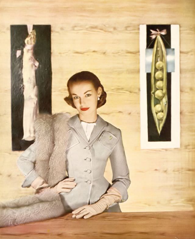 #22 Liz Pringle in narrow, pale gray flannel suit by Lilli Ann, white linen gilet by Emily Wetherby, Harper’s Bazaar U.S., February 1952