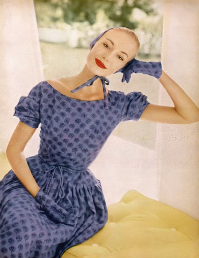 #40 Liz Pringle in violet floral silk surah print sheath with floating shirred apron by Adele Simpson, April 1955