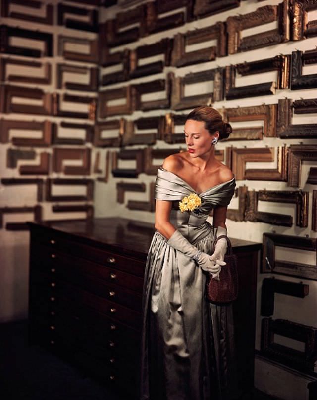 #32 Meg Mundy in silver satin evening dress that bares the shoulders in a fichu of folds by Jack Herzog, Harper’s Bazaar, November 1947