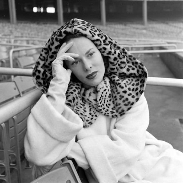 #37 Meg Mundy wearing white wool coat with leopard fur hood, Harper’s Bazaar, October 1947