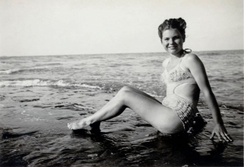 #22 A young lady in a so-called Monokini swimsuit posing on the beach. The print is dated “1948” on reverse, 1948