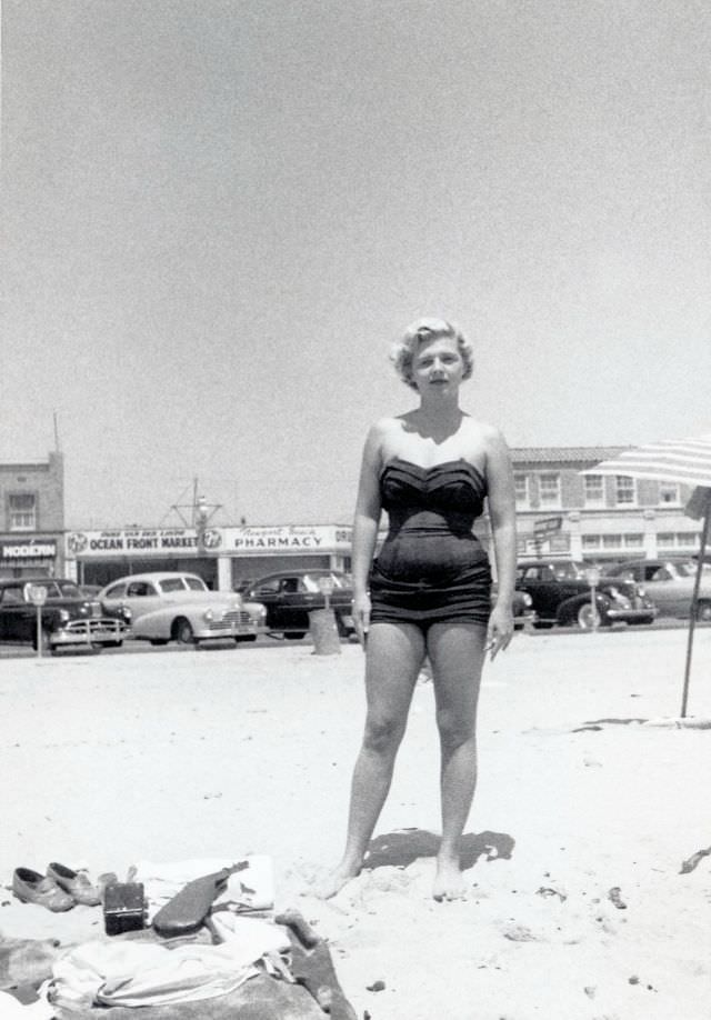 #25 A platinum-blonde lady in a one-piece swimsuit posing on a sunny beach.