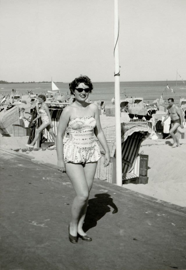 #37 A young brunette lady in a fashionable one-piece swimsuit posing at the seaside, 1950s