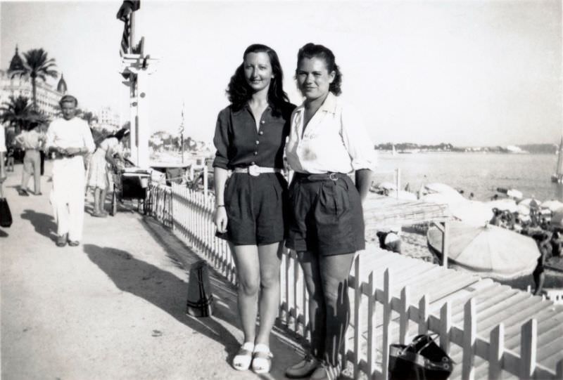#39 Two young ladies posing on a seaside promenade in the town of Cannes on the French Riviera, 1950s