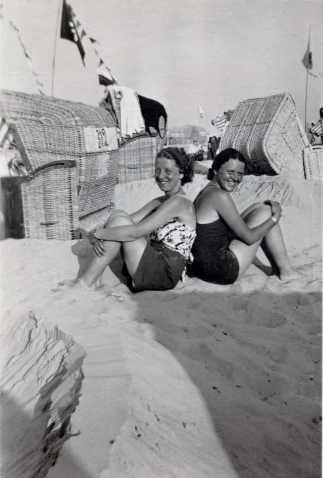 #7 Two cheerful young ladies posing on a sandy beach, suntan in progress.