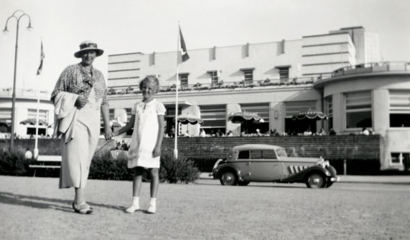 #9 A fashionable lady and her daughter posing in front of a distinctive Art déco building in summertime.