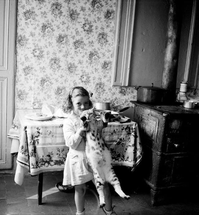 #42 Girl holding cat in East End habitat, Rouen, September 1951