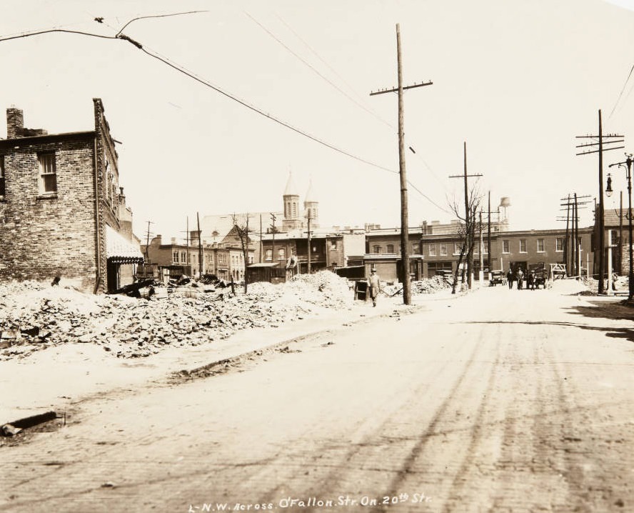 #149 Piles of bricks on a lot near the intersection of O’Fallon and 20th streets in 1920, with the twin spires of St. Stanislaus Kostka church visible in the distance.