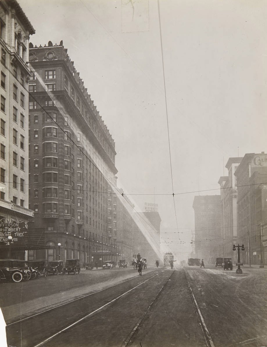 #151 A spotlight shining down on a policeman directing traffic on 12th street near Olive St. in 1920, with the Hotel Jefferson visible on the west side of the street.