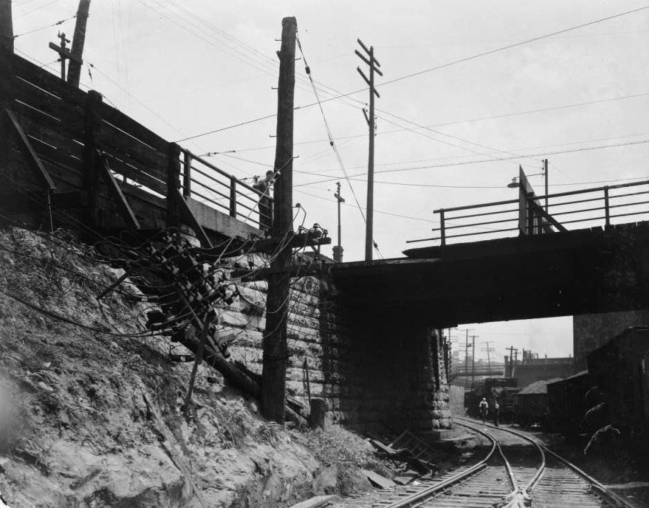 #175 View of a damaged utility pole at train tracks, 1925