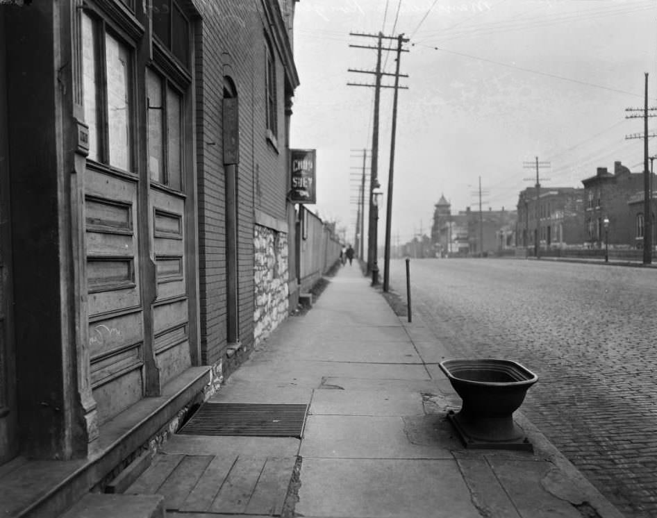 #61 East view down Manchester Ave. from the intersection with Kingshighway Blvd., with a sign reading “Chop Suey” on a dwelling in foreground and a lodge hall with a pointed tower at 4512-4514 Manchester Ave. in center distance, 1925