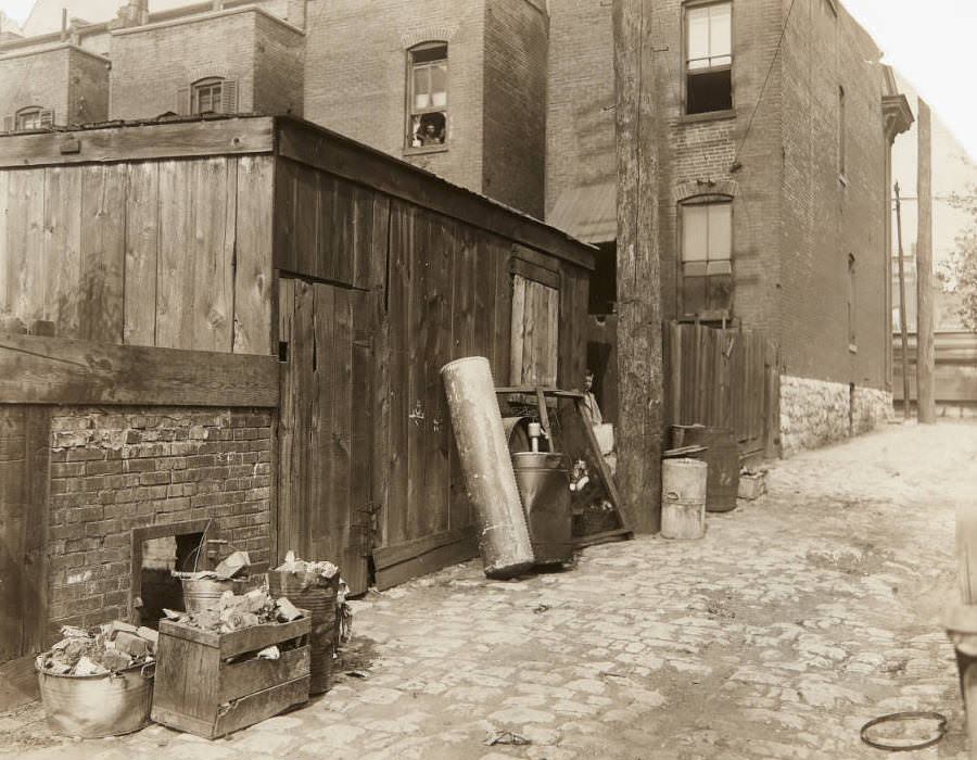 #22 Small wooden building and debris in an alley near Grand Avenue during “Clean up” week, 1920