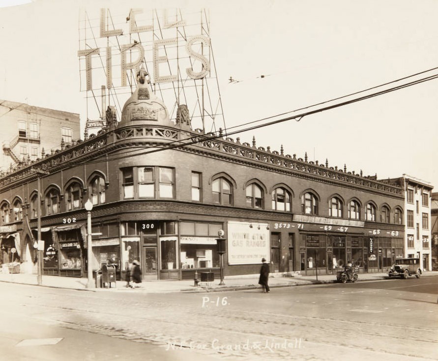 #108 Marina Building at 306 N. Grand at its intersection with Lindell with Grand Garcia Cigar, Lee Tires, and Jay Long Laundry storefronts, 1920