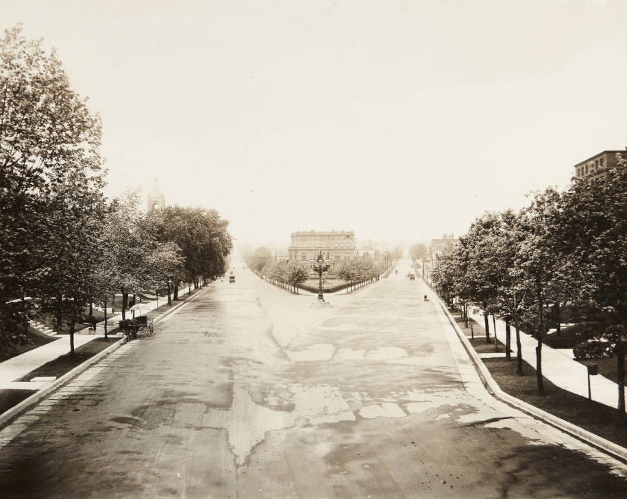 #116 Looking west on McPherson Avenue where it ends at Lindell Blvd. near the northern edge of the St. Louis University campus with a man cleaning the sidewalk on the south side of the street, 1920.