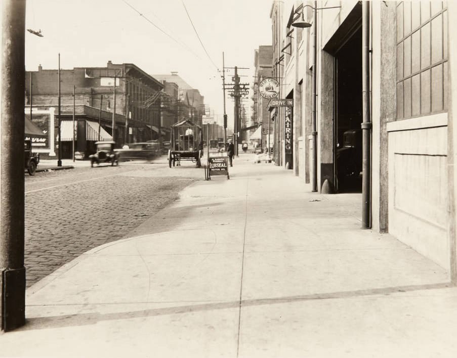 #137 Auto repair garage on Wash St in 1920. The sign in the middle of the image reads, “No Parking Between this Point. Wash St.”