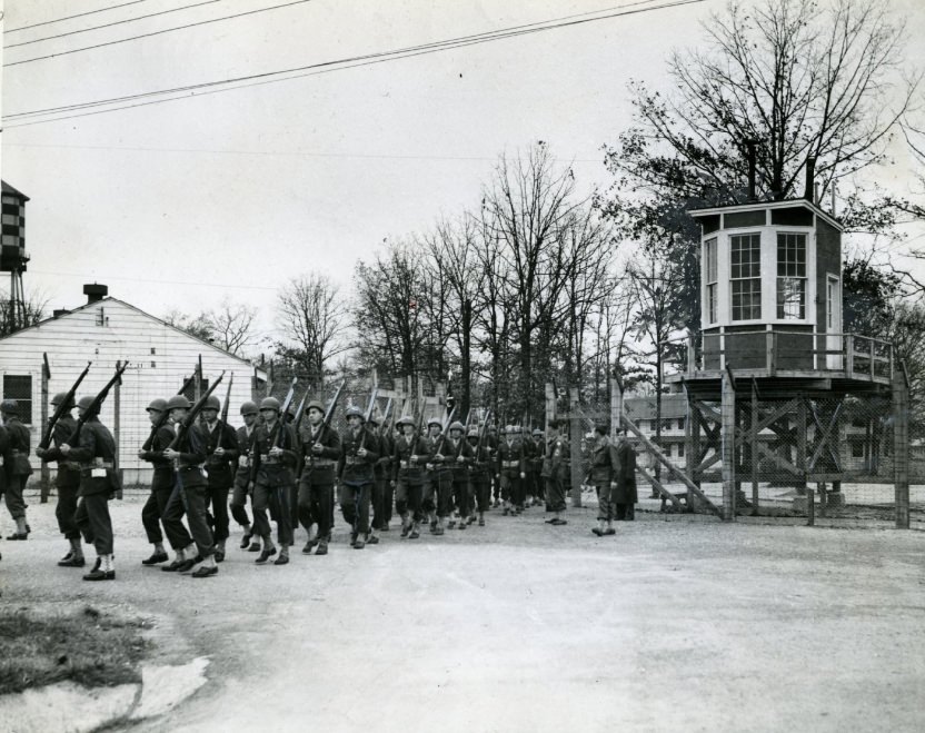 #70 From Behind A Barricade And In The Shadow Of A Guard Tower March Soldiers Who Are Confined, 1944