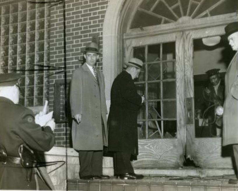#104 Police officers inspect scene of a bombing at the AFL bricklayers’ union, 1953