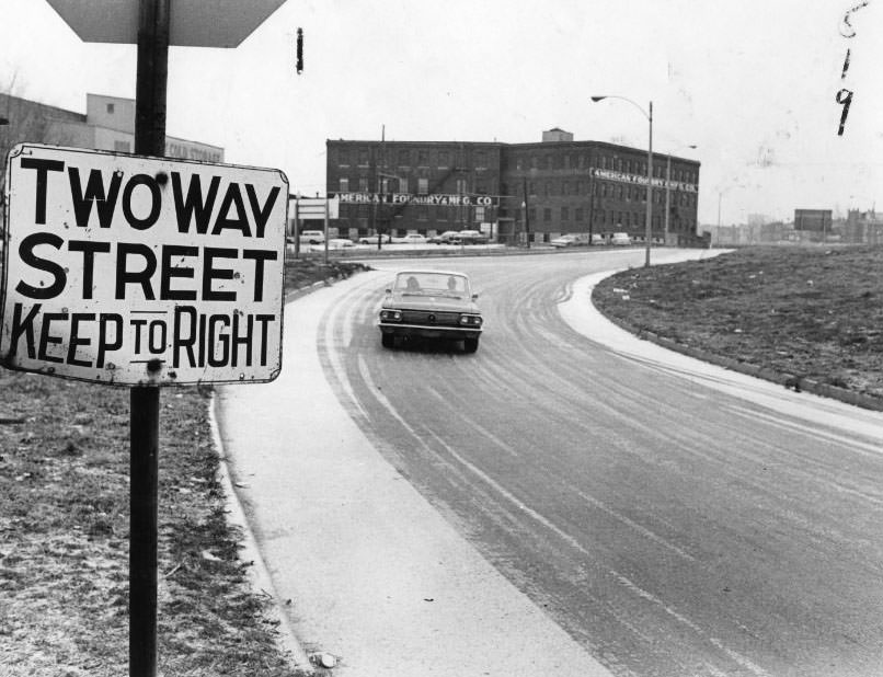 #218 Arrows point to “Two Way Traffic-Keep Right” signs (enlargement below) on south curb at Branch street at west branch of Branch street exit from Interstate 70, 1960