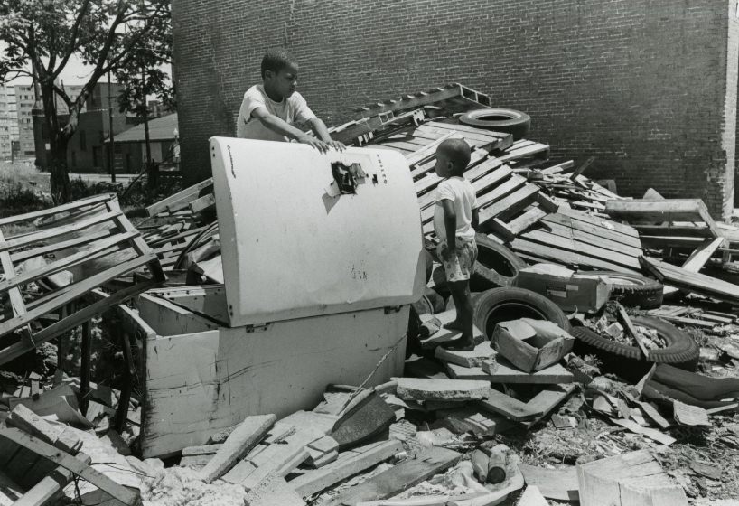 #146 Two children search through debris left by a building after it was destroyed, 1970