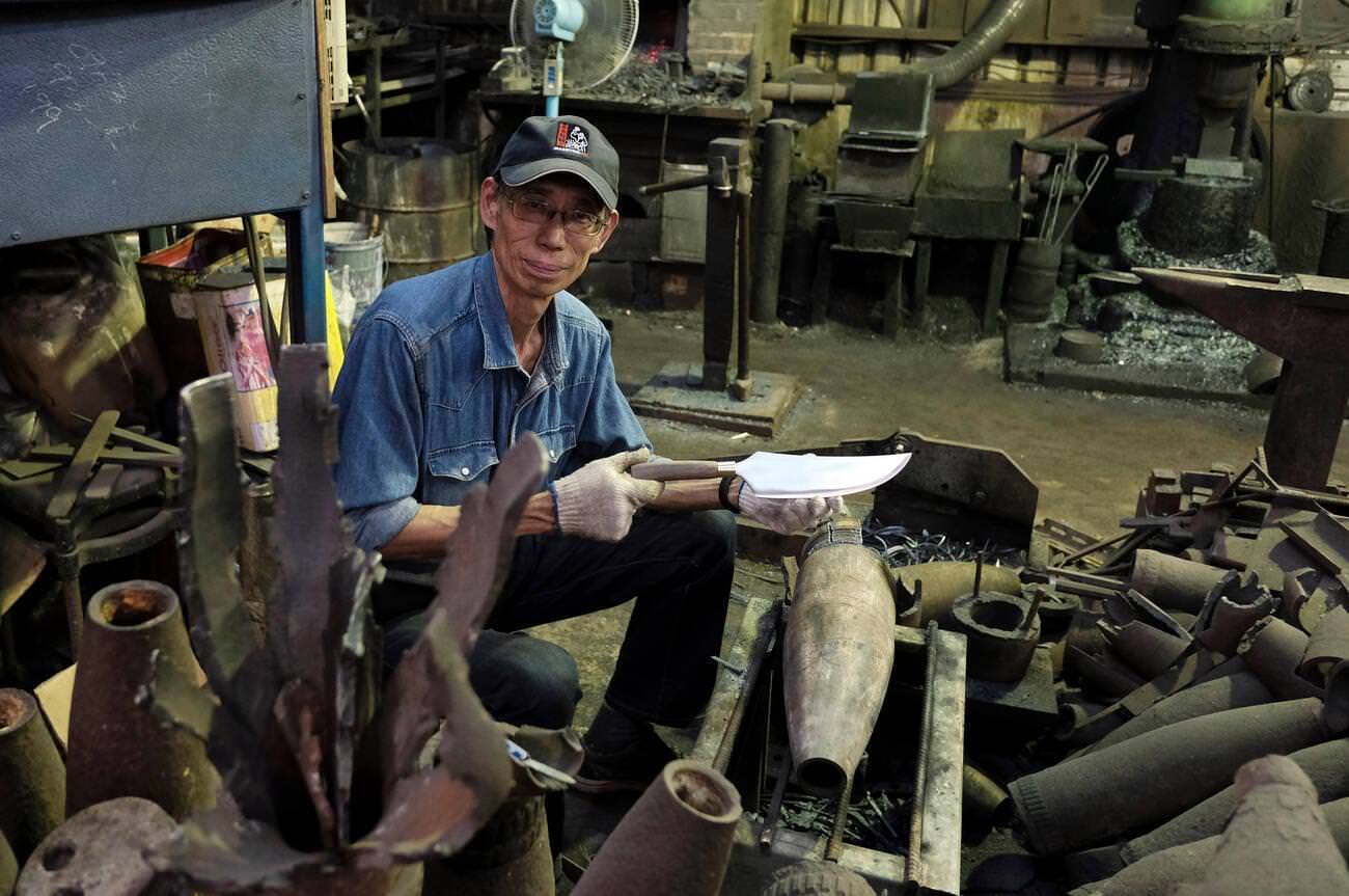 #41 Taiwanese blacksmith Wu Tseng-tong known as Maestro Wu crafts a knife from recovered artillery shells in Kinmen County or island few miles from mainland China, Taiwan, 1950s