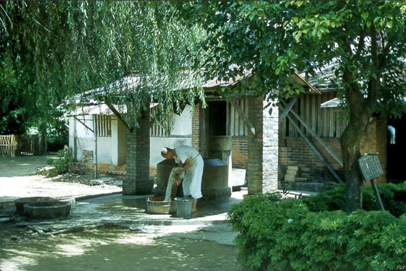 #35 A monk doing laundry beside a well inside the monastery, Tainan, Taiwan, 1954