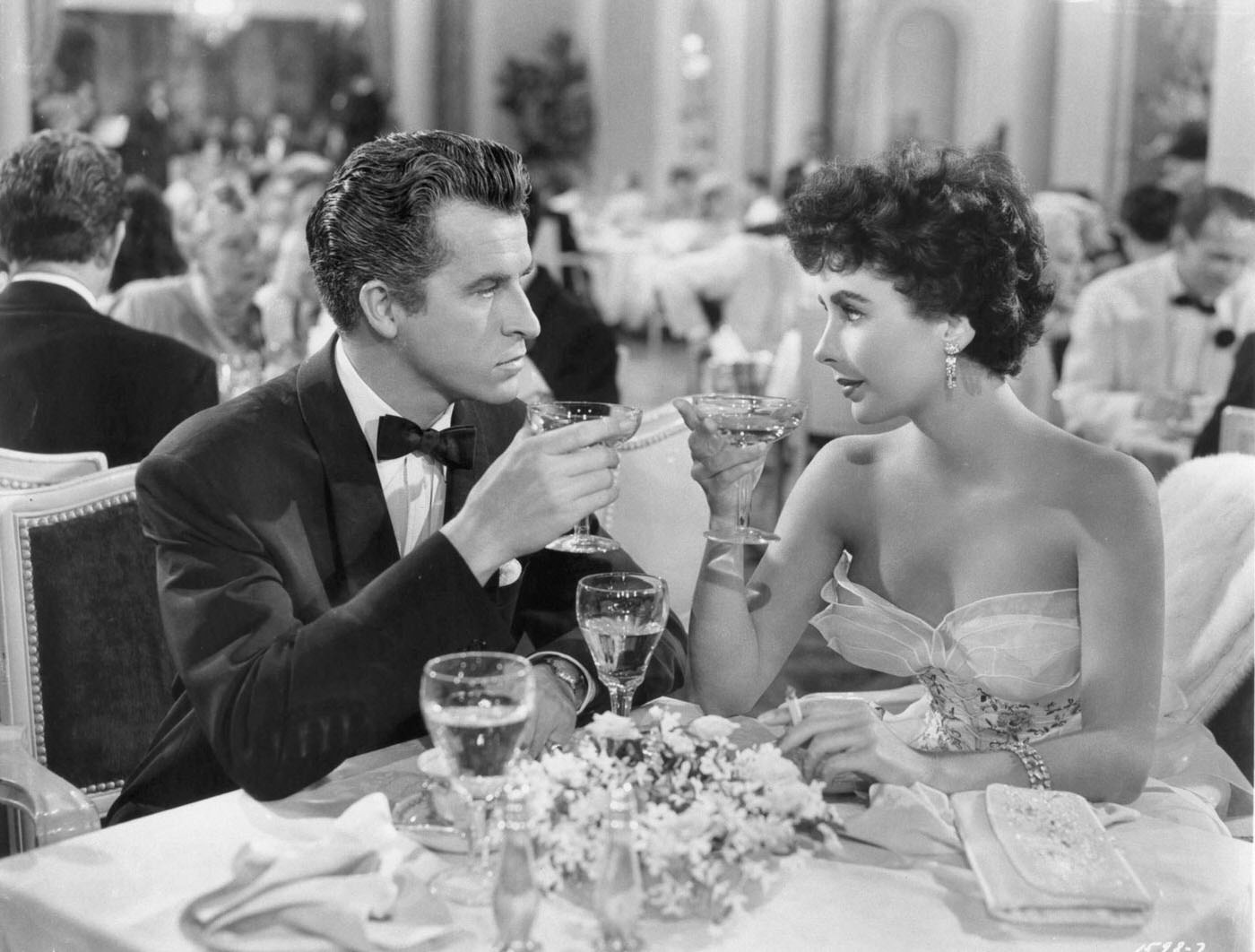 Fernando Lamas and Elizabeth Taylor share a drink in a scene from ‘Girl Who Had Everything’ (1953).