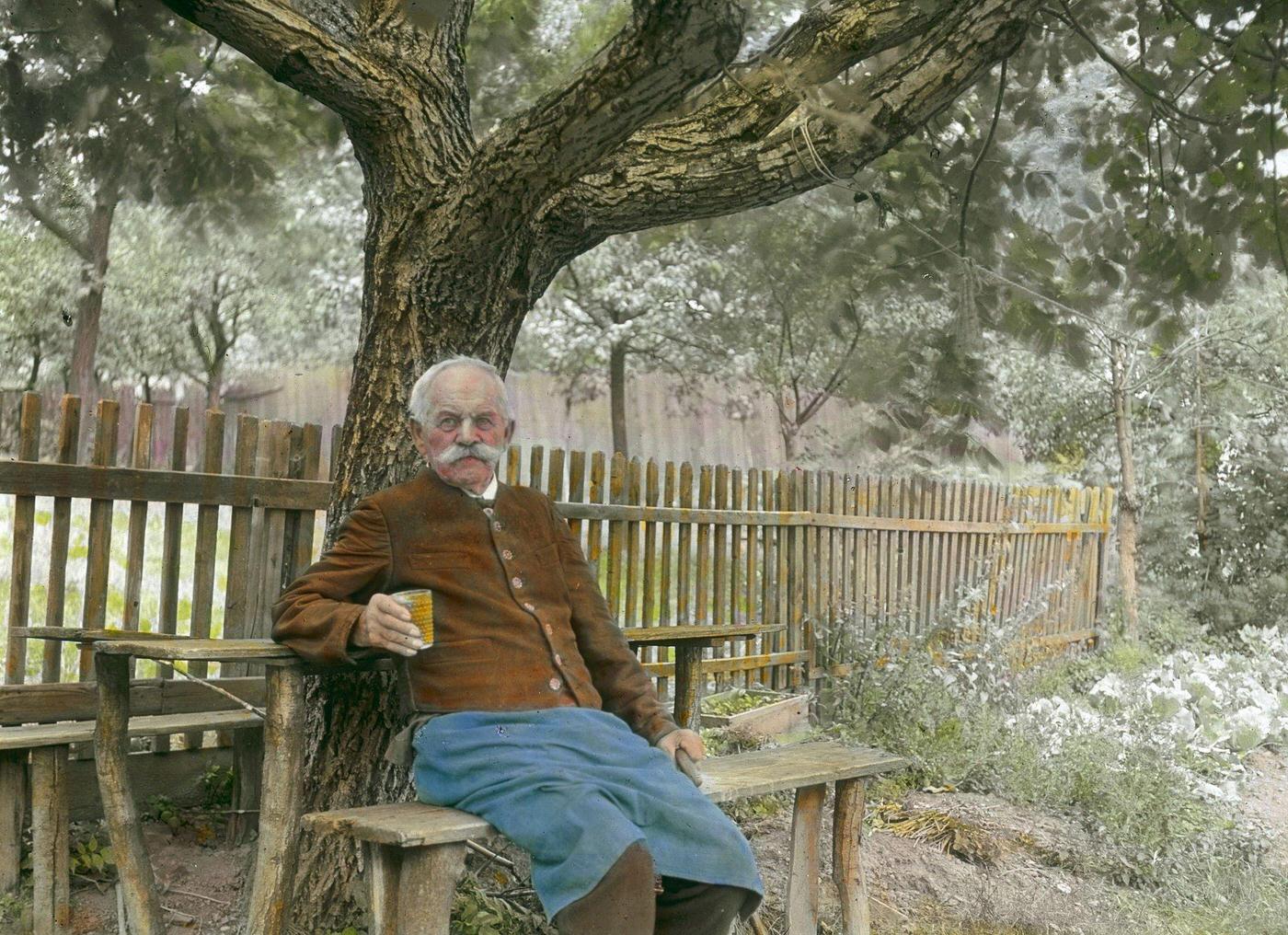 #57 Elderly winemaker sitting on a bench. Hand-colored lantern slide, 1905.