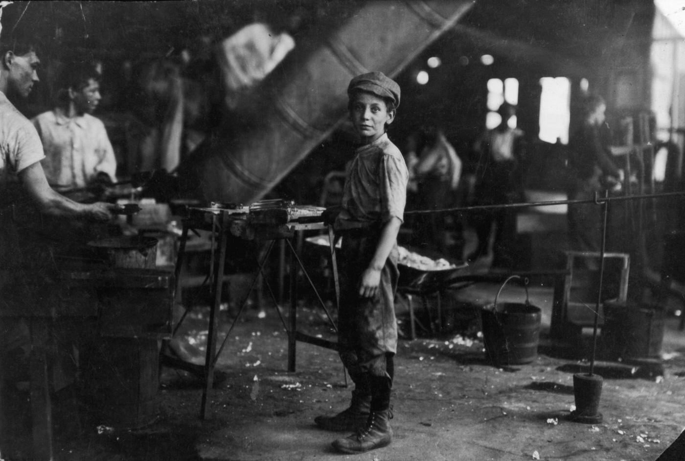 #57 Aboy standing near men on the floor of a glass factory, Alexandria, Virginia, 1911