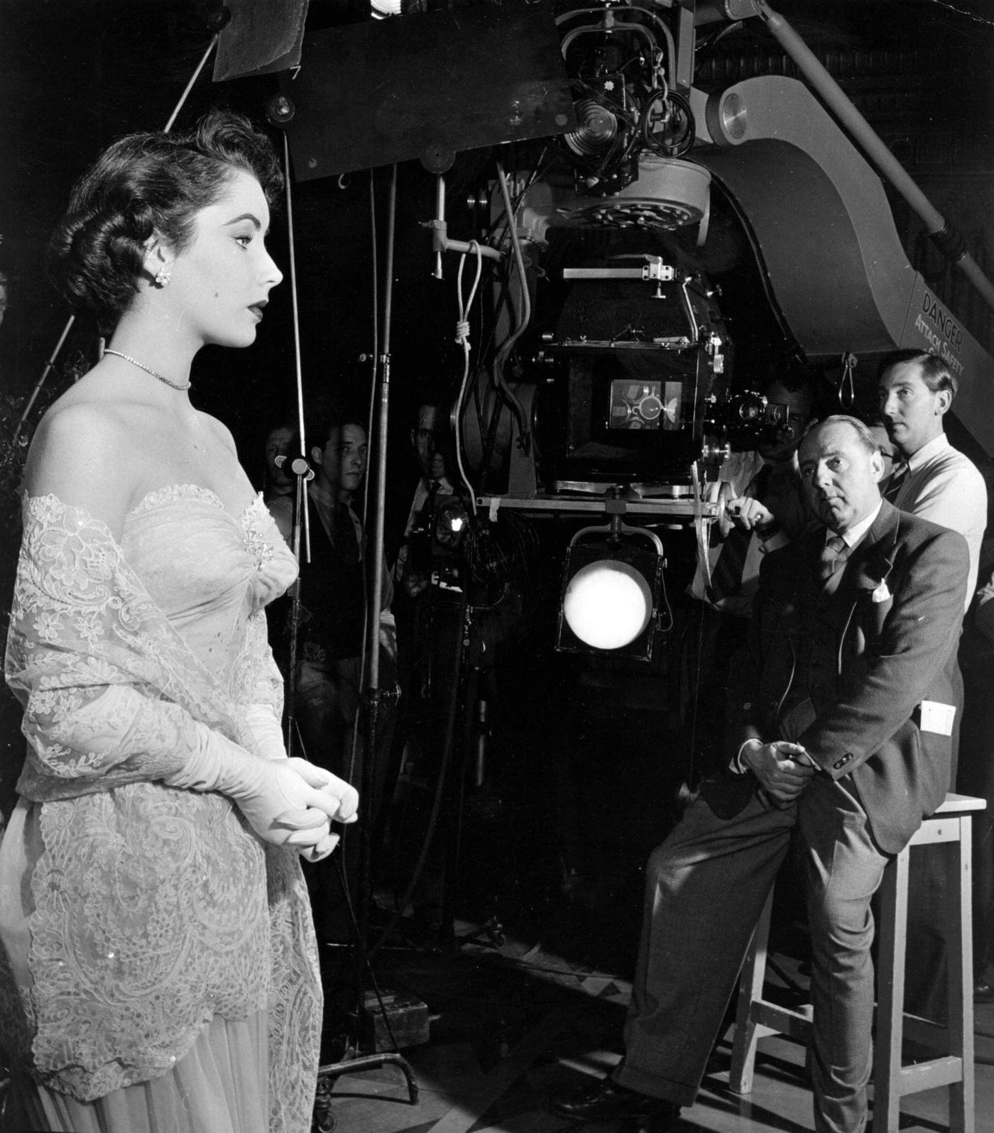 #11 Elizabeth Taylor on the set of the film ‘Conspirator’ with director Victor Saville.