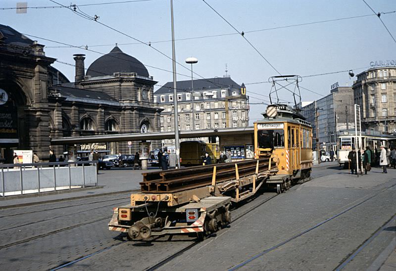 #2 Frankfurt 4-wheel Arbeitswagen (works tram) 2040 passing the tram stops in front of Frankfurt Hauptbahnhof. The trailer wagon is carrying six lengths of new tram rail, March 30, 1967