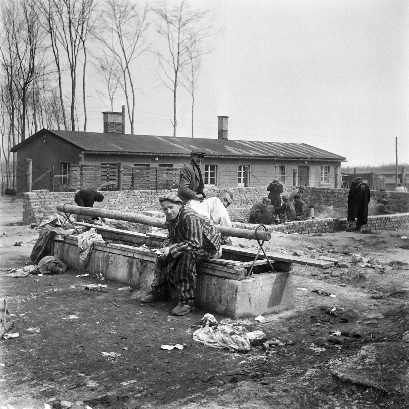 #20 Survivors of Buchenwald concentration camp sitting on a latrine after its liberation by Allied troops in April 1945.
